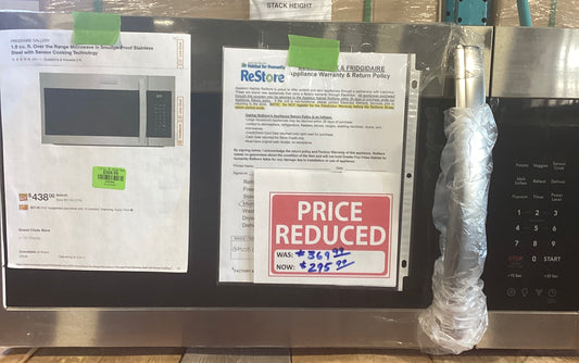 A microwave with papers on it, indicating a discount and information about the product.