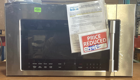 A microwave with papers on it, indicating warranty and discount information