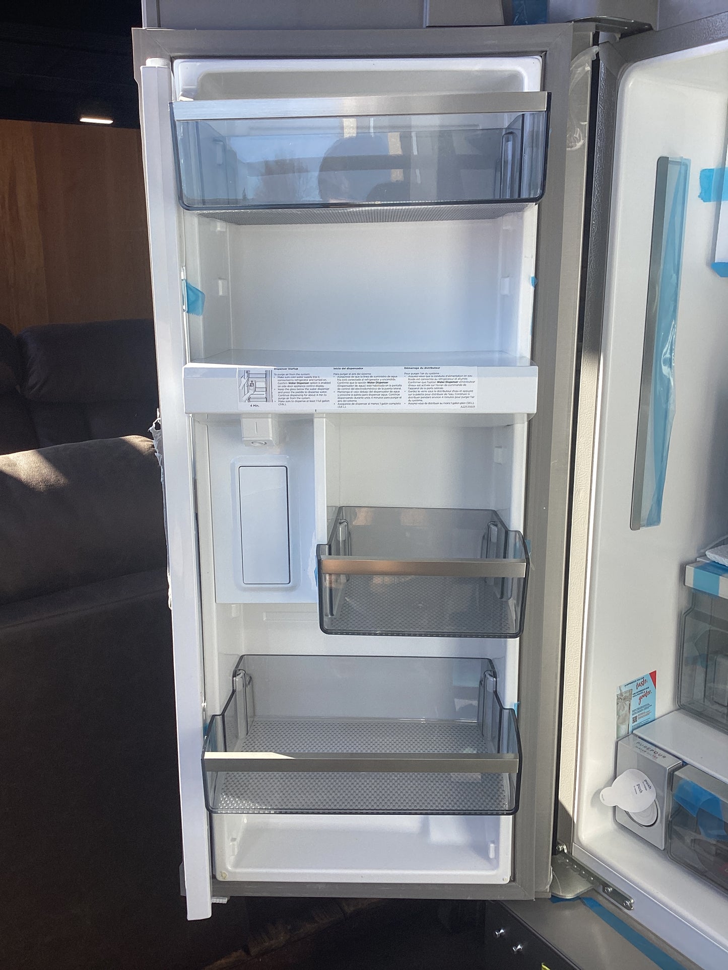 A refrigerator with open doors, showing shelves and compartments inside.