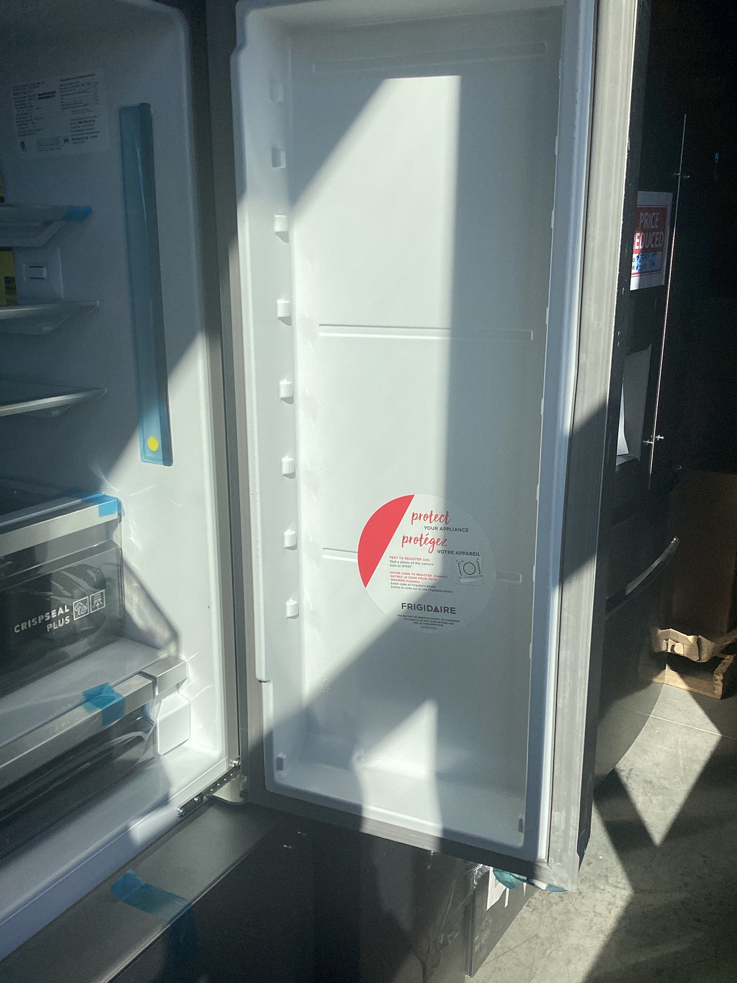 A refrigerator with open doors, showing shelves and compartments inside.