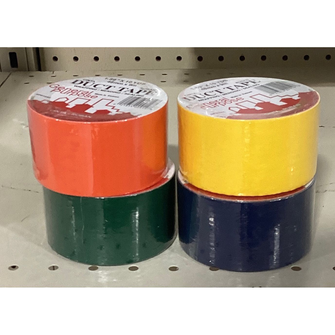 Four rolls of colored duct tape neatly arranged on a shelf.