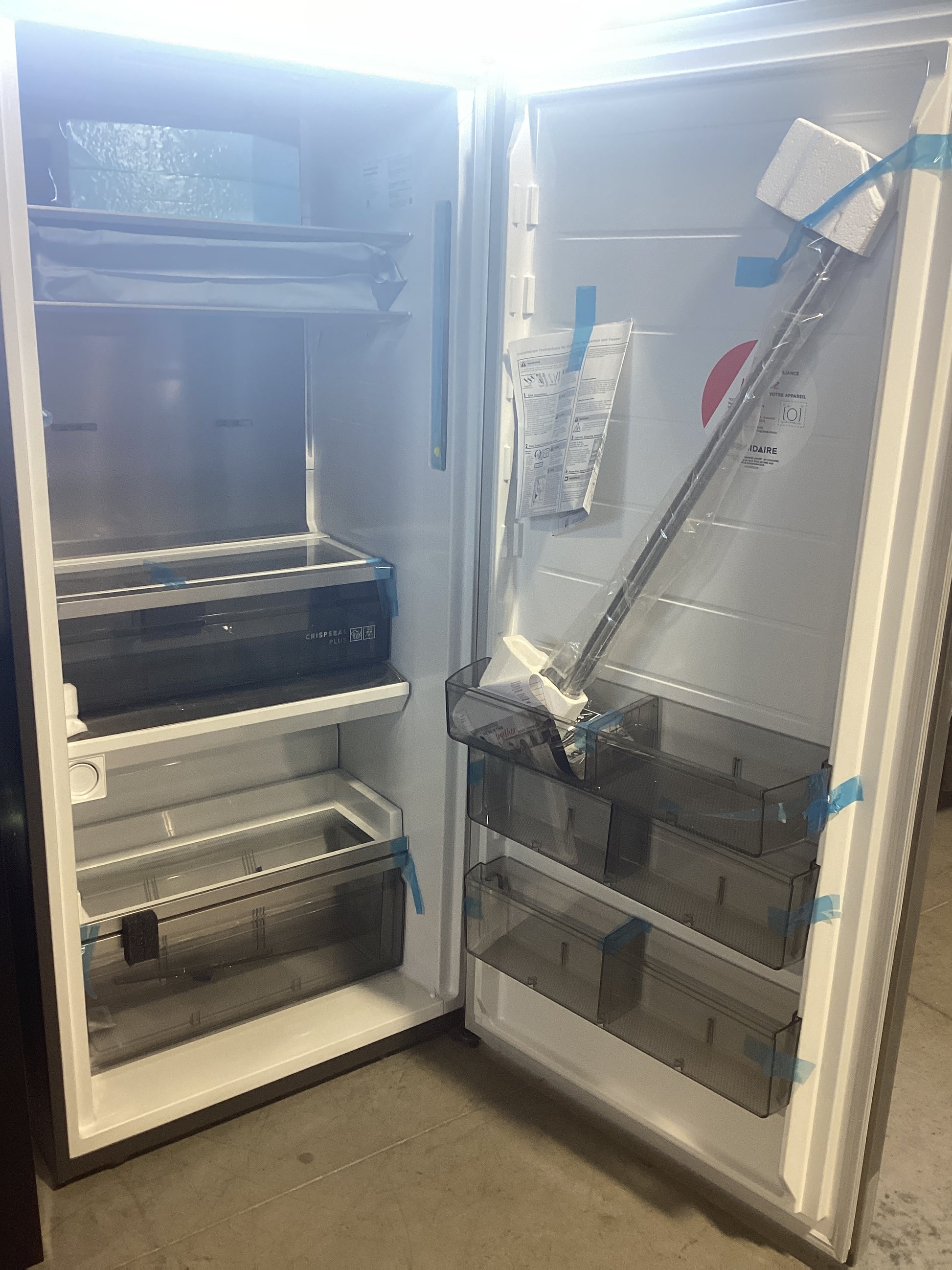 A refrigerator with open door revealing freezer inside, ready to store frozen goods.