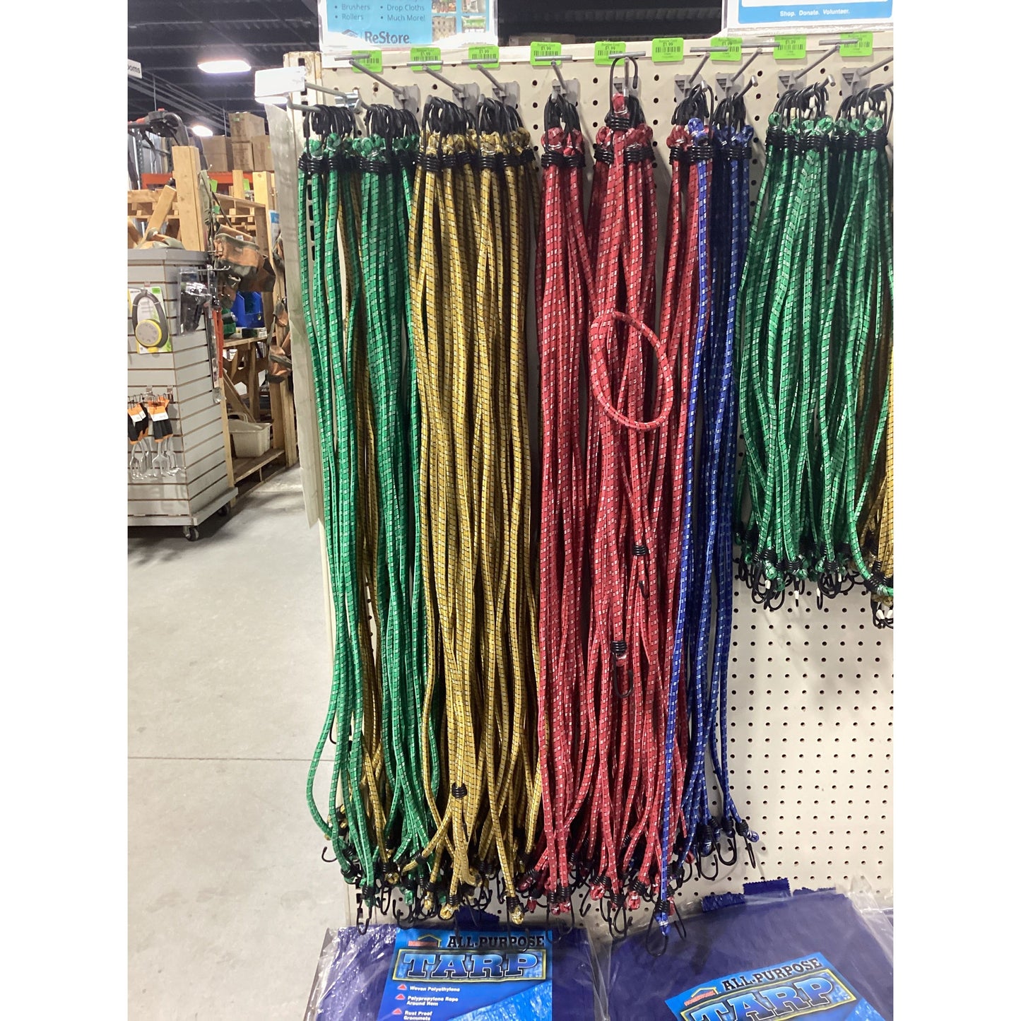 A rack with various colored Bungee Cords.