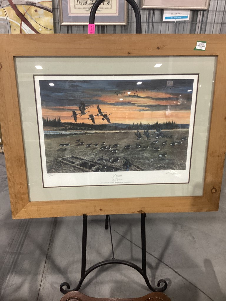 A painting of geese, with some on the ground and some flying in the air and a sunset in the sky
