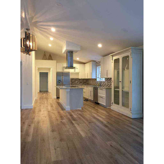 A spacious kitchen with white cabinets and hardwood floors.