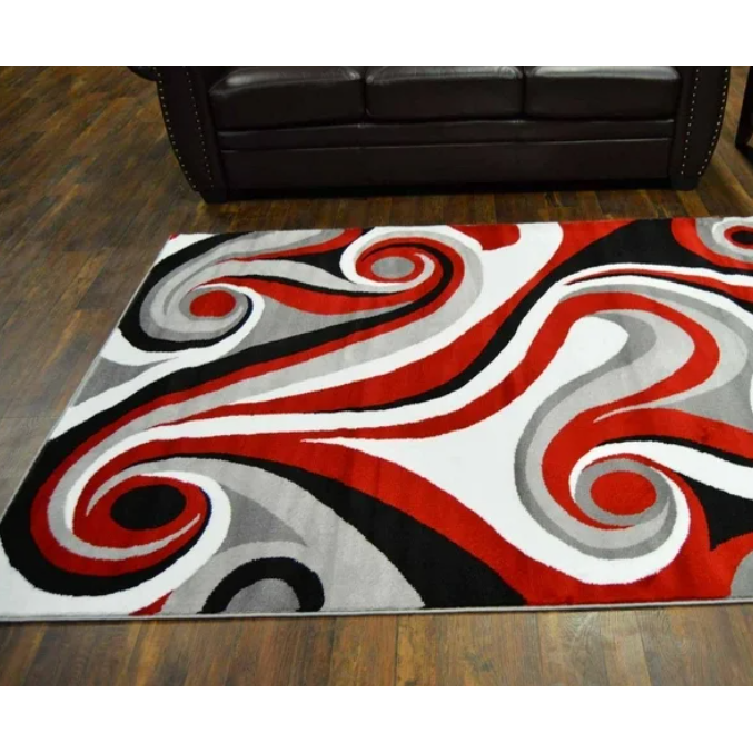 A vibrant area rug with a swirling design in red, black, and white.