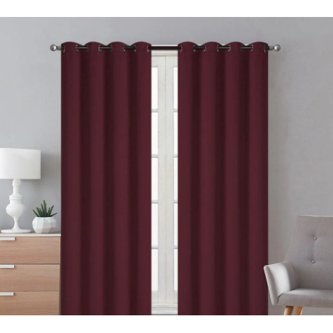 Burgundy blackout curtains hanging in a room, blocking out sunlight and providing privacy.
