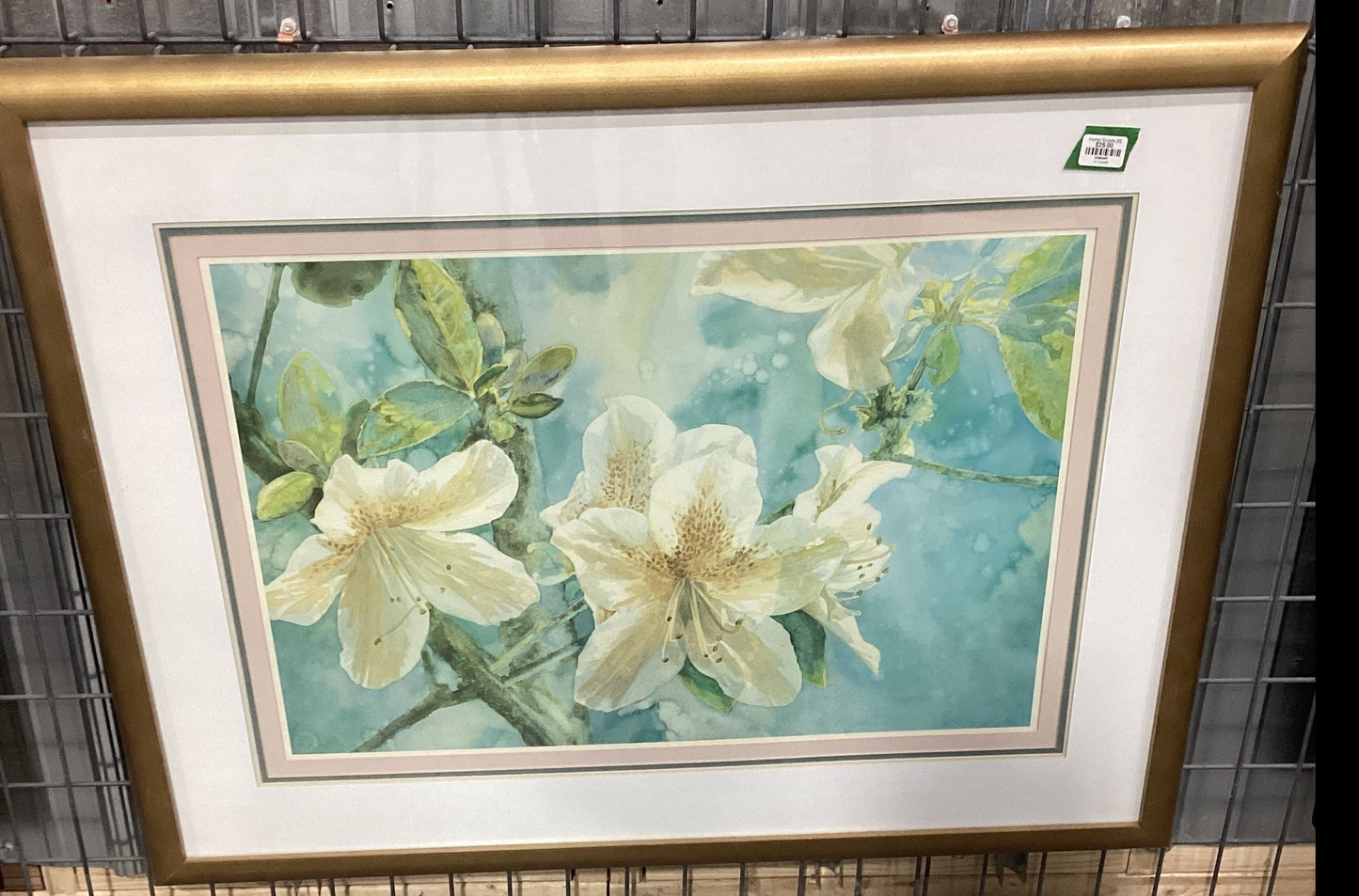 A framed painting of white flowers hanging on a wall.
