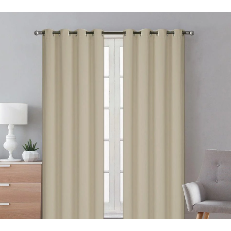Ivory blackout curtains hanging in a room, blocking out sunlight and providing privacy.