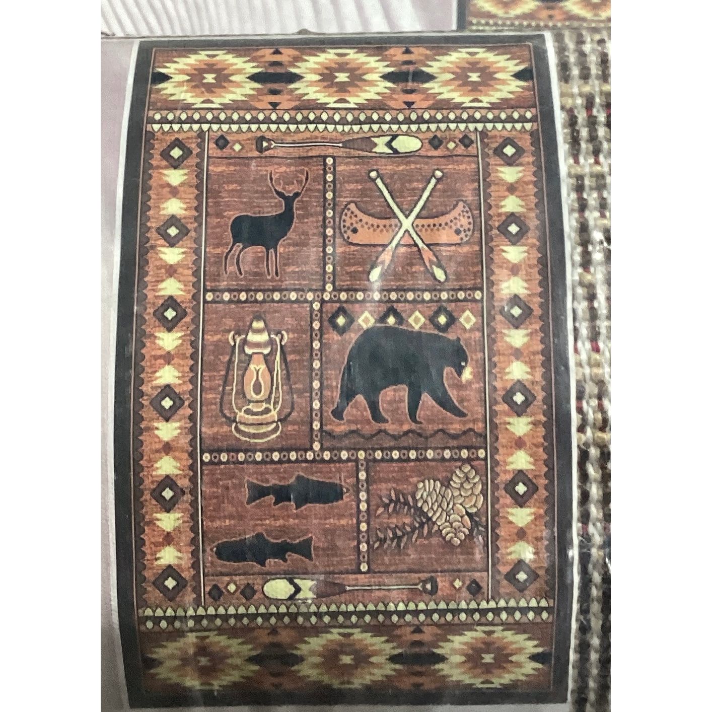 A rug featuring a bear, deer, and various other animals.