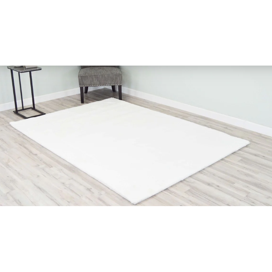 A 5x8 Timmy Shaggy White rug on a hardwood floor in a room.